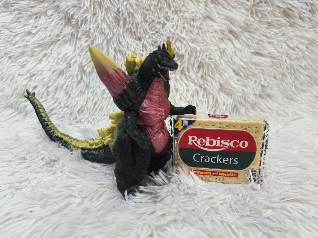 Godzilla Toy Figures (Category: Figurines & Statues) located in Pasig City. Submitted by 1stop-shop (Listing ID 1437651901, Image 3). Description: - Godzilla figures available! - ₱300.00 each - Large Godzilla: - Features yellow and red dorsal fin. - Size reference: Rebisco crackers box. - Small Godzilla: - Black figure. - Size reference: Battery..