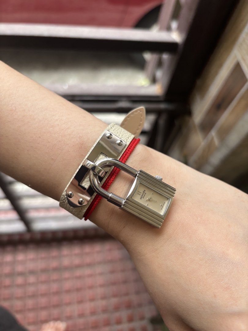Hermes Kelly Watch (Category: Luxury Watches) located in Subic. Submitted by loveforluxe. (Listing ID 1437605168, Image 1). Description: - Hermes Kelly watch - Silver-tone case - Rectangular dial - Cream-colored dial with silver-tone hands and hour markers - Unique padlock-shaped clasp - White leather strap.