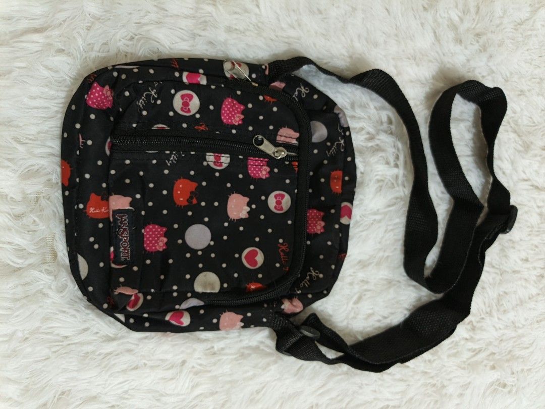 Jansport Hello Kitty Crossbody Bag (Category: Cross-body Bags) located in Marikina City. Submitted by andreah_16 (Listing ID 1437640838, Image 2). Description: - Jansport crossbody bag - Black base with Kitty and polka dot pattern - Front zippered pocket - Main compartment - Adjustable black strap - Approximately 8 inches wide.