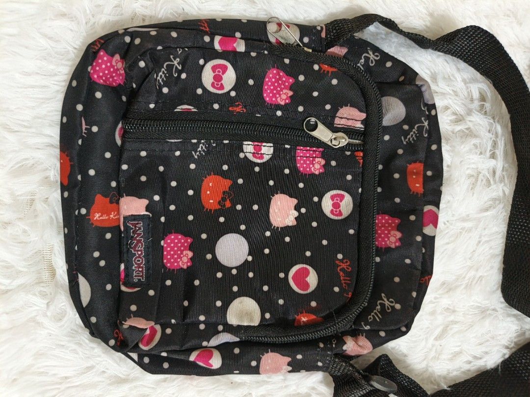 Jansport Hello Kitty Crossbody Bag (Category: Cross-body Bags) located in Marikina City. Submitted by andreah_16 (Listing ID 1437640838, Image 3). Description: - Jansport crossbody bag - Black base with Kitty and polka dot pattern - Front zippered pocket - Main compartment - Adjustable black strap - Approximately 8 inches wide.