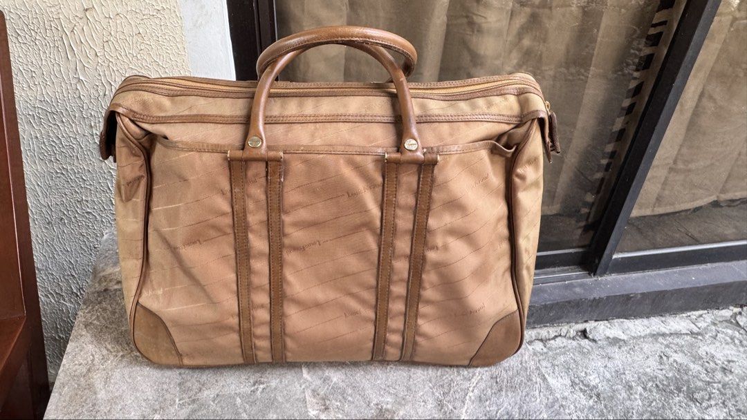 Louis Feraud (Category: Luxury Bags & Wallets) located in Santa Cruz. Submitted by maqui15 (Listing ID 1437592963, Image 2). Description: Louis feraud bag in a tan color. It features a top handle design with a spacious interior. The bag has a zipper closure and multiple compartments. The interior lining has a repeating pattern. It includes a leather key holder. The bag has leather accents and details..