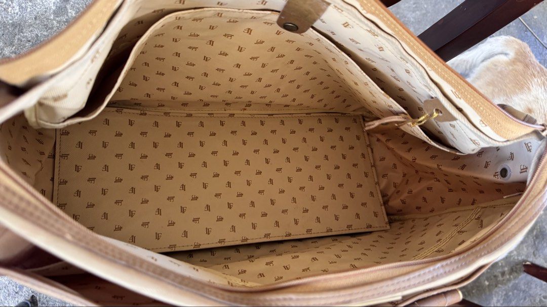 Louis Feraud (Category: Luxury Bags & Wallets) located in Santa Cruz. Submitted by maqui15 (Listing ID 1437592963, Image 3). Description: Louis feraud bag in a tan color. It features a top handle design with a spacious interior. The bag has a zipper closure and multiple compartments. The interior lining has a repeating pattern. It includes a leather key holder. The bag has leather accents and details..