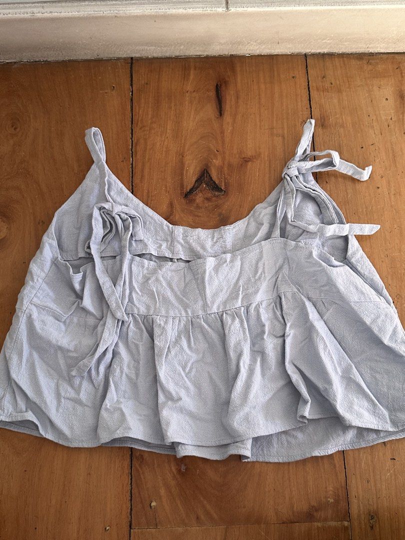 Light Blue Tie-Strap Crop Top (Category: Sleeveless) located in Quezon City. Submitted by cam.declutters (Listing ID 1437669205, Image 2). Description: - Light blue crop top - Tie straps - Gathered hem - V-neckline - Slightly textured fabric - Back tie details - Easy to pair with high-waisted bottoms - Simple, summery style.