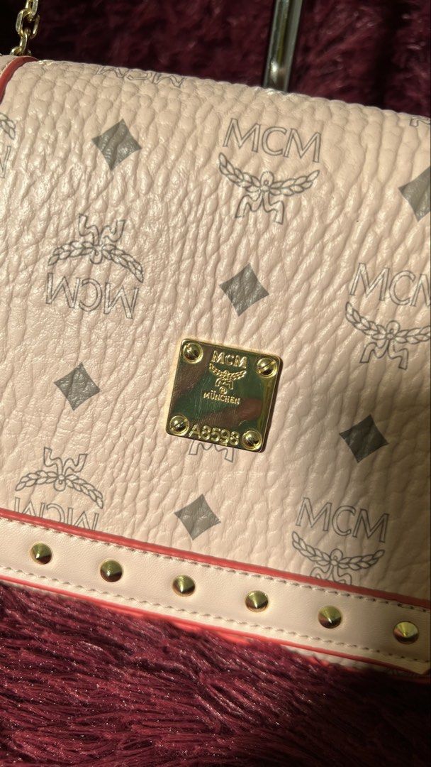 MCM Crossbody Bag with Chain Strap (Category: Luxury Bags & Wallets) located in Muntinlupa City. Submitted by armendaber03743 (Listing ID 1437737099, Image 2). Description: - MCM Crossbody Bag - Chain strap and flap closure - Signature MCM logo pattern - Light pink exterior with red trim - Gold-tone hardware and studded details - Includes a small gold plaque with the MCM logo - Features a serial number.