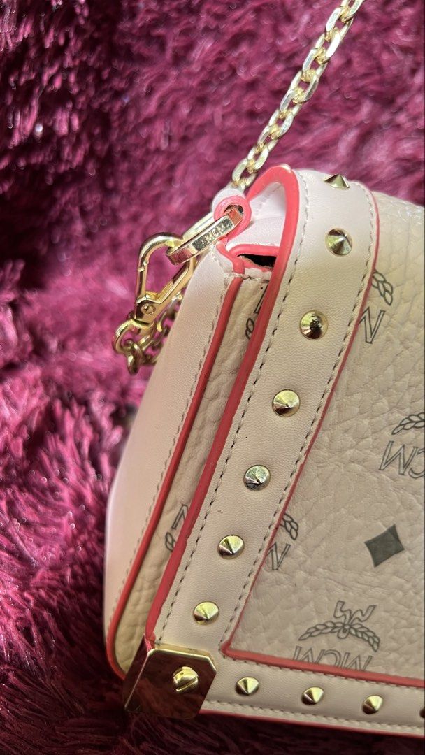 MCM Crossbody Bag with Chain Strap (Category: Luxury Bags & Wallets) located in Muntinlupa City. Submitted by armendaber03743 (Listing ID 1437737099, Image 3). Description: - MCM Crossbody Bag - Chain strap and flap closure - Signature MCM logo pattern - Light pink exterior with red trim - Gold-tone hardware and studded details - Includes a small gold plaque with the MCM logo - Features a serial number.