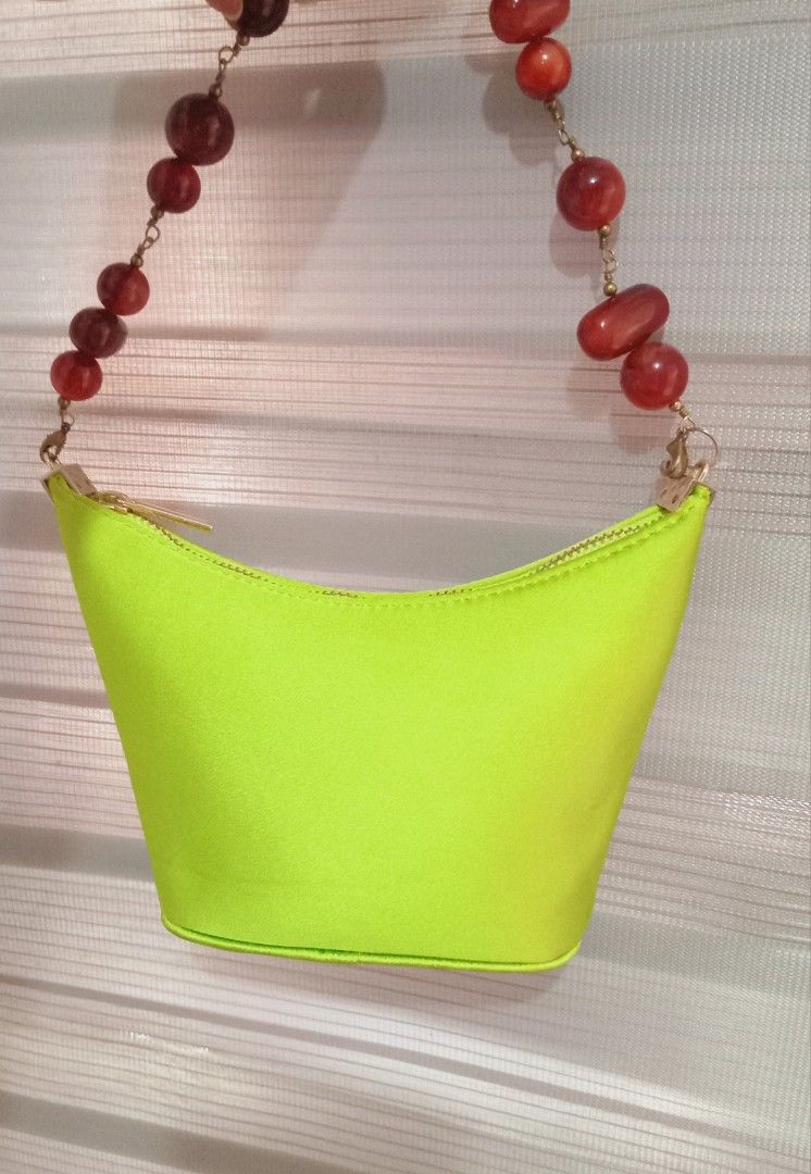 Neon Green Handbag with Beaded Strap (Category: Purses & Pouches) located in Rodriguez. Submitted by maycol (Listing ID 1437742429, Image 3). Description: - Neon green handbag - Unique beaded strap (reddish-brown beads) - Zippered closure - Structured, bucket-like shape - Perfect for any outfit -rare.