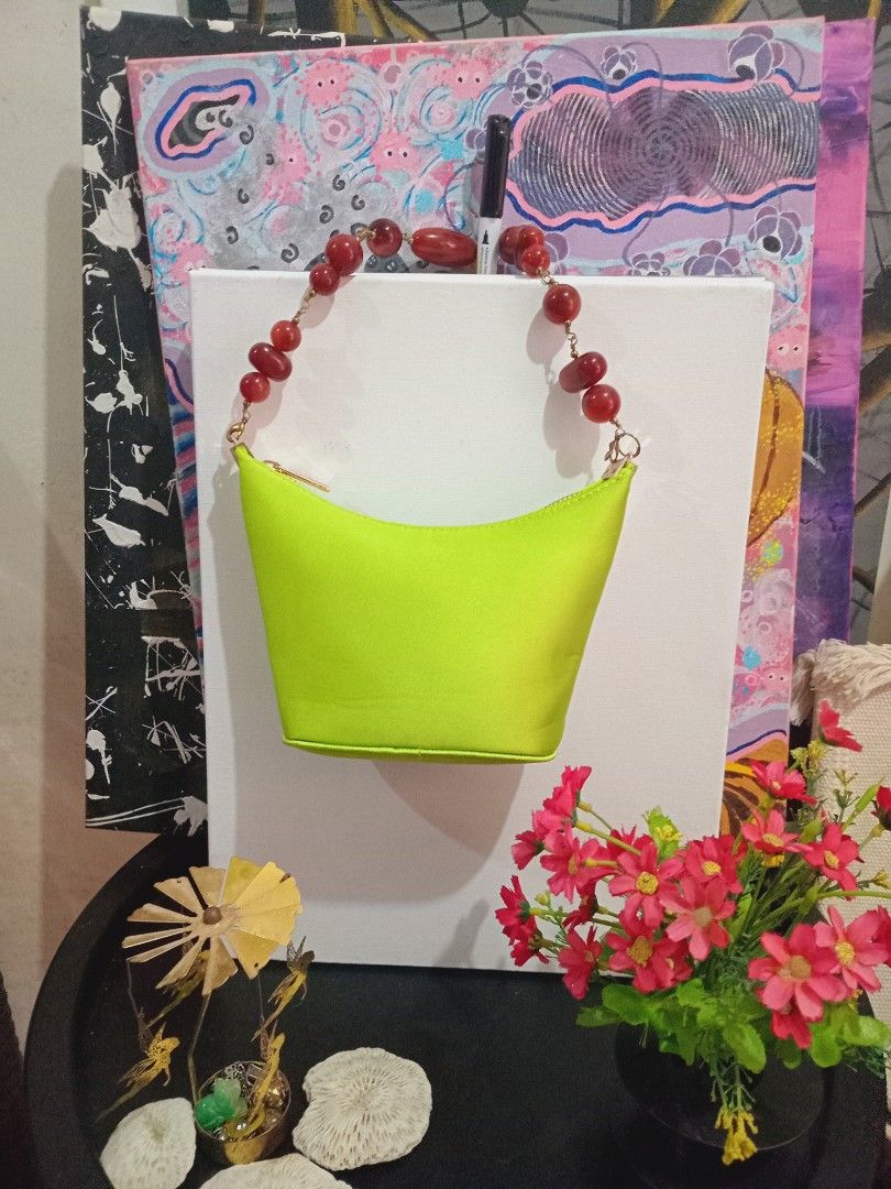 Neon Green Handbag with Beaded Strap (Category: Purses & Pouches) located in Rodriguez. Submitted by maycol (Listing ID 1437742429, Image 2). Description: - Neon green handbag - Unique beaded strap (reddish-brown beads) - Zippered closure - Structured, bucket-like shape - Perfect for any outfit -rare.
