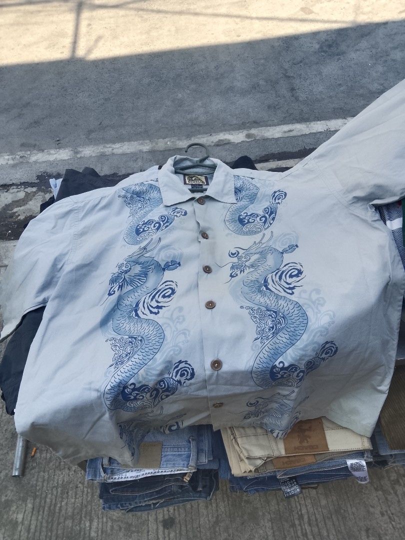 Quiksilver Dragon Print Shirt (Category: Tshirts & Polo Shirts ) located in Quezon City. Submitted by theoneshop1 (Listing ID 1437743451, Image 2). Description: - Quiksilver shirt - Unique dragon print - Button-down closure - Collared neckline - Light color with blue dragon detailing - Size: L/L - Made in India - Classic, casual style.
