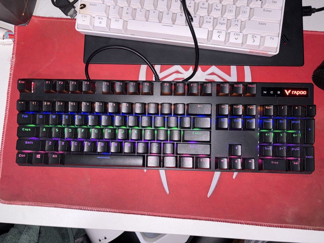 Rapoo NCS Mechanical Keyboard (Category: Computer Keyboard) located in Noveleta. Submitted by vayandels (Listing ID 1437731783, Image 2). Description: Mechanical keyboard with RGB backlighting. Features a full-sized layout with a black frame and keycaps. The keyboard has a wired connection. The Rapoo logo is visible on the top right corner. The keycaps have a standard layout with clear lettering. -still negotiable for sure transactions.