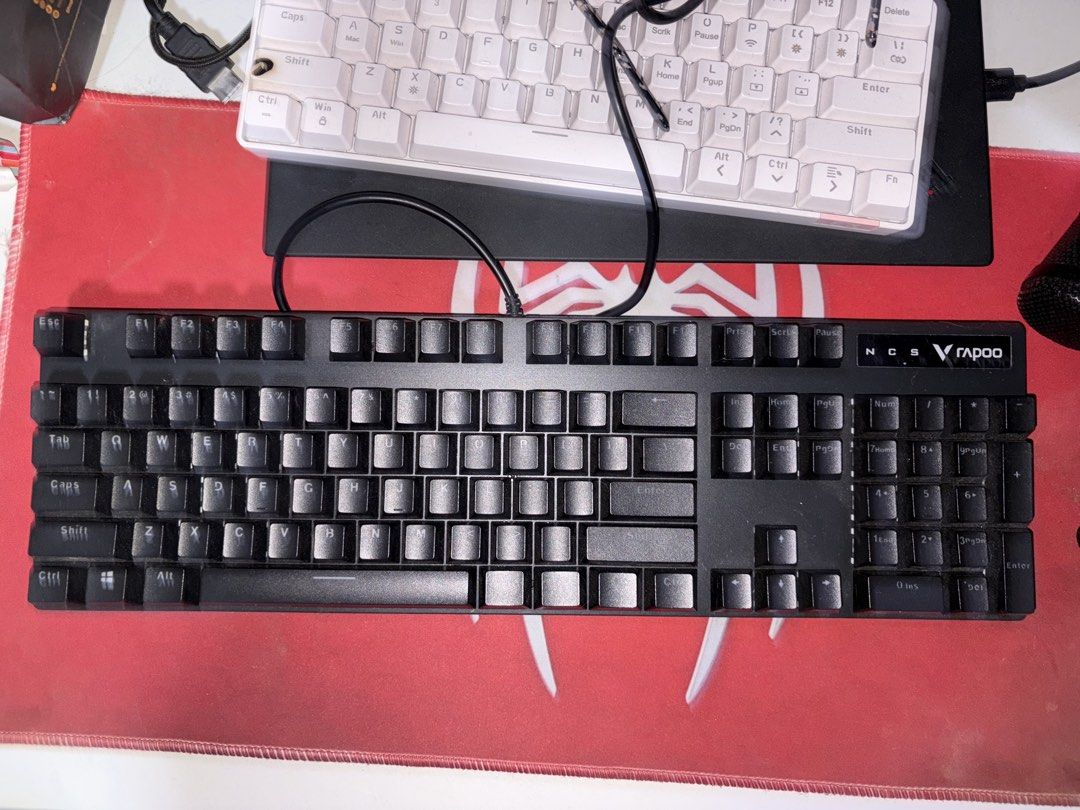 Rapoo NCS Mechanical Keyboard (Category: Computer Keyboard) located in Noveleta. Submitted by vayandels (Listing ID 1437731783, Image 3). Description: Mechanical keyboard with RGB backlighting. Features a full-sized layout with a black frame and keycaps. The keyboard has a wired connection. The Rapoo logo is visible on the top right corner. The keycaps have a standard layout with clear lettering. -still negotiable for sure transactions.