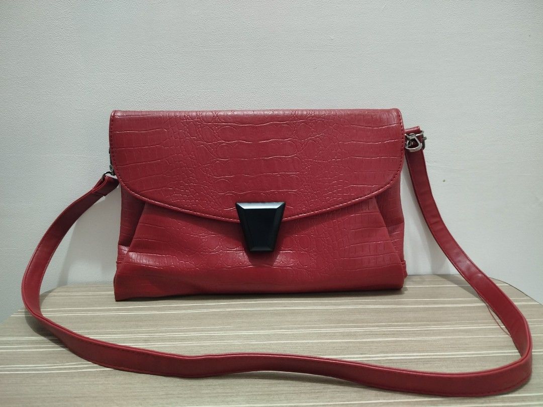 Red Crocodile Embossed Large Crossbody Bag (Category: Cross-body Bags) located in Cavite. Submitted by prncs.jc (Listing ID 1437715186, Image 1). Description: Product Description: - Item: Red Crocodile Embossed Large Crossbody Bag - Color: Crimson Red - Material: Crocodile Skin / Embossed Leather - Closure: Front flap with a bold black trapezoidal magnetic buckle - Handle/Strap: Long, adjustable matching red leather crossbody strap with silver-to