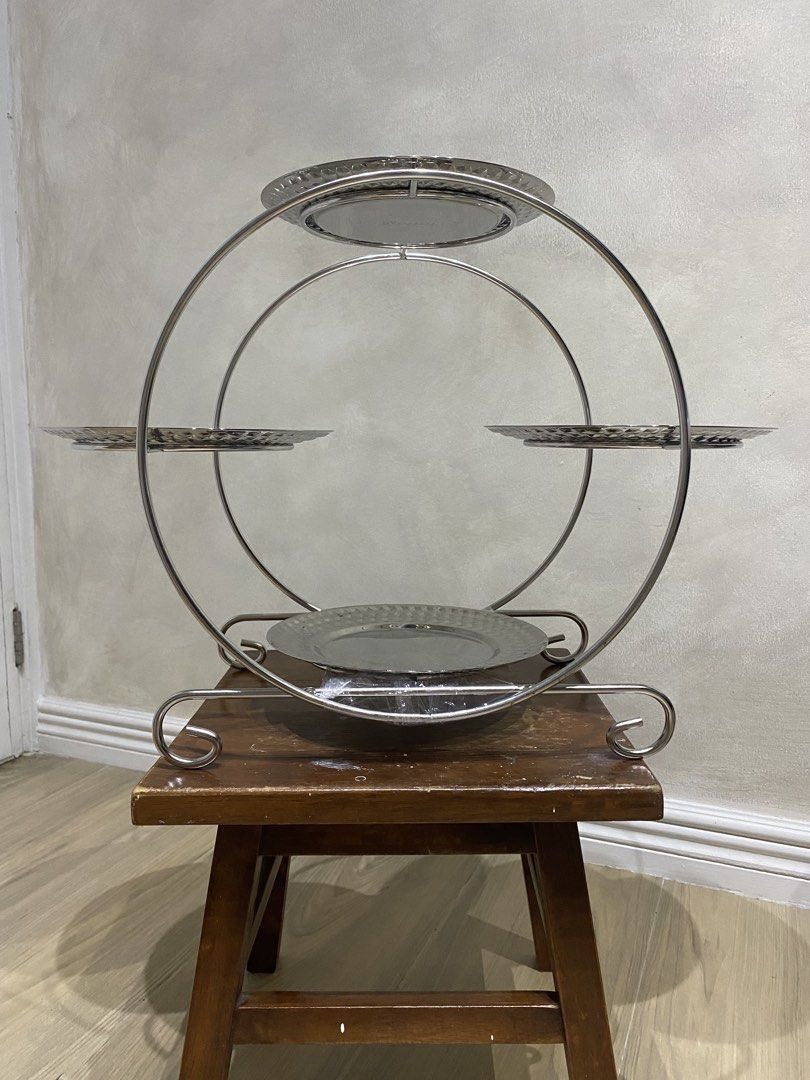 Rossetti 4-Tier Silver Dessert Tray (Category: Other Kitchenware & Tableware) located in Manila. Submitted by papupeeps (Listing ID 1437649414, Image 2). Description: Modern Design: The minimalist, geometric metal frame provides a contemporary look that complements any decor. Textured Plates: Each of the four tiers features a classic hammered metal pattern, adding a touch of sophisticated detail and helping to hide minor scratches or fingerprints