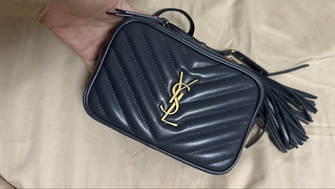 Saint Laurent Lou Camera belt Bag (Category: Luxury Bags & Wallets) located in Quezon City. Submitted by mema0522 (Listing ID 1437603589, Image 1). Description: - Authentic Saint Laurent Lou Camera Bag - Dark blue color - Quilted design - Gold YSL logo - Detachable tassel - Crossbody strap - Includes dust bag, tags, and Saint Laurent pouch - Zip closure - Compact design Flaws on the glazing, I tried to DIY it kasi need ko na gamitin next day pero