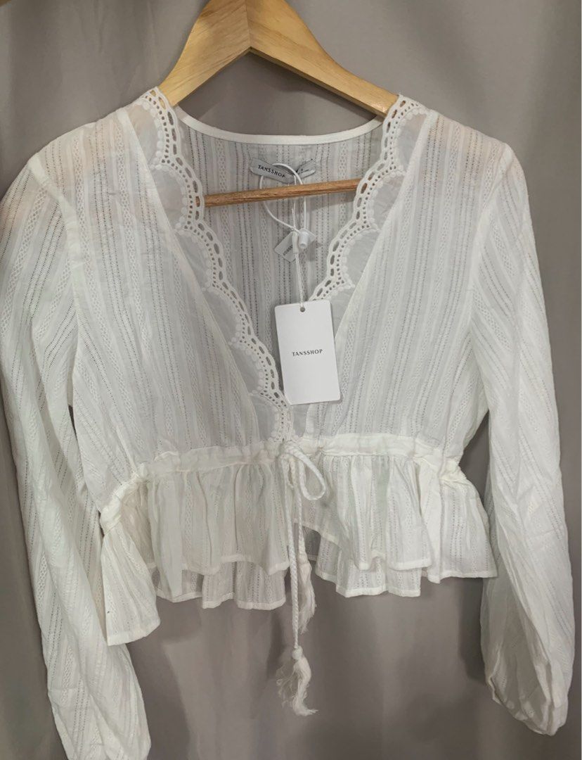 Tannshop White Long Sleeve Blouse (Category: Blouses) located in Manila. Submitted by decluterthings888 (Listing ID 1437589765, Image 1). Description: - Tannshop white blouse - Long sleeves - V-neck with lace detail - Drawstring waist - Ruffled hem - Lightweight, textured fabric ❌NO BRAND PRELOVED CLOTHES GOOD QUALITY.