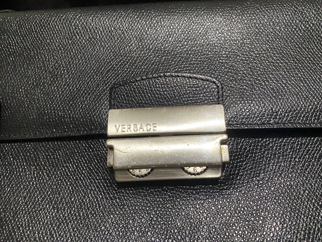 Versace Black Trifold Flap Leather Envelope (Category: Luxury Bags & Wallets) located in Manila. Submitted by resi.diaz (Listing ID 1437724653, Image 2). Description: - Bought from Surplus. - Not professionally authenticated. - Sold as is. - Top handle design - Front clasp closure with Versace branding - Textured leather exterior - Iconic Medusa head logo - Convenient back zippered pocket.