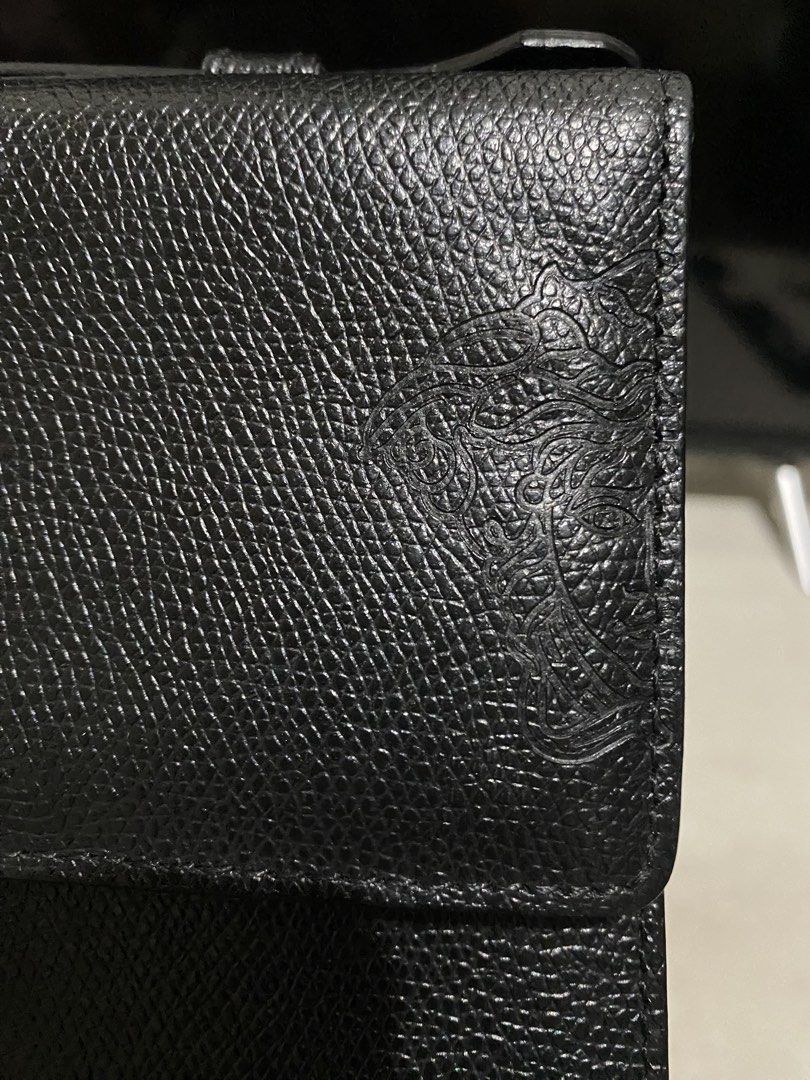 Versace Black Trifold Flap Leather Envelope (Category: Luxury Bags & Wallets) located in Manila. Submitted by resi.diaz (Listing ID 1437724653, Image 3). Description: - Bought from Surplus. - Not professionally authenticated. - Sold as is. - Top handle design - Front clasp closure with Versace branding - Textured leather exterior - Iconic Medusa head logo - Convenient back zippered pocket.