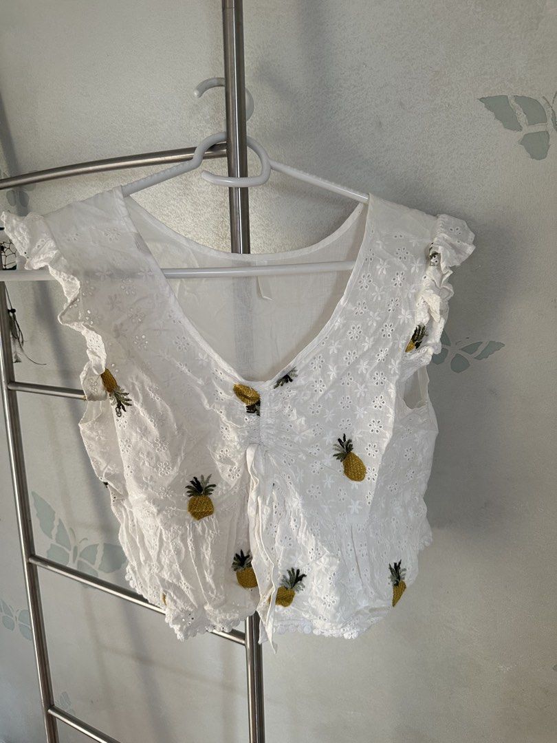 White Pineapple Embroidered Top (Category: Blouses) located in Quezon City. Submitted by cam.declutters (Listing ID 1437668819, Image 2). Description: - White top with embroidered pineapple details - V-neckline - Ruffled sleeves - Drawstring detail - Made of lightweight, breathable fabric - Ideal for warm weather.