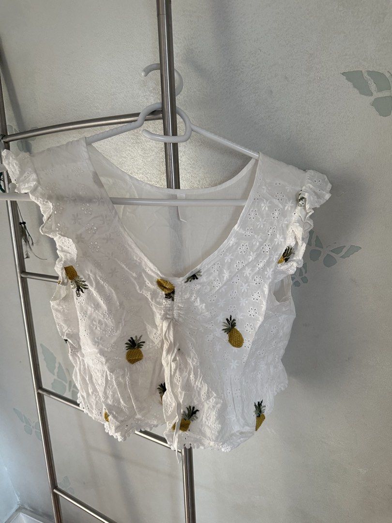 White Pineapple Embroidered Top (Category: Blouses) located in Quezon City. Submitted by cam.declutters (Listing ID 1437668819, Image 1). Description: - White top with embroidered pineapple details - V-neckline - Ruffled sleeves - Drawstring detail - Made of lightweight, breathable fabric - Ideal for warm weather.