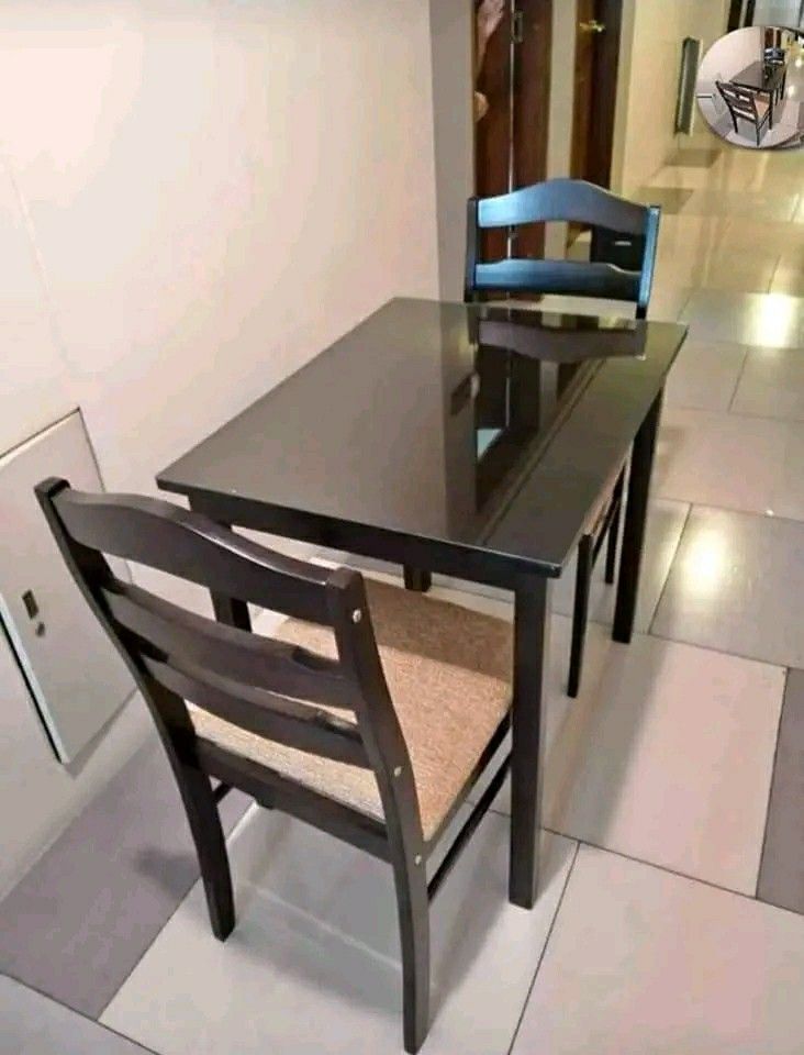 Wooden Dining Table with Chairs (Category: Tables & Sets) located in Manila. Submitted by jerrymieborda05 (Listing ID 1437746961, Image 1). Description: - Dark brown wooden dining table - Includes matching chairs with cushioned seats - Rectangular table design - Suitable for small dining areas - Glossy wood finish.