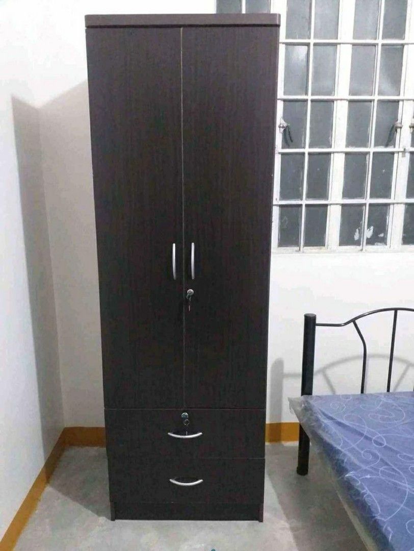 Wooden Wardrobe with Drawers (Category: Shelves, Cabinets & Racks) located in Manila. Submitted by jerrymieborda05 (Listing ID 1437746092, Image 1). Description: - Dark brown wooden wardrobe - Two doors and two drawers - Includes a hanging rod - Features a lock and handles - Ideal for bedroom storage - Tall with a simple design.