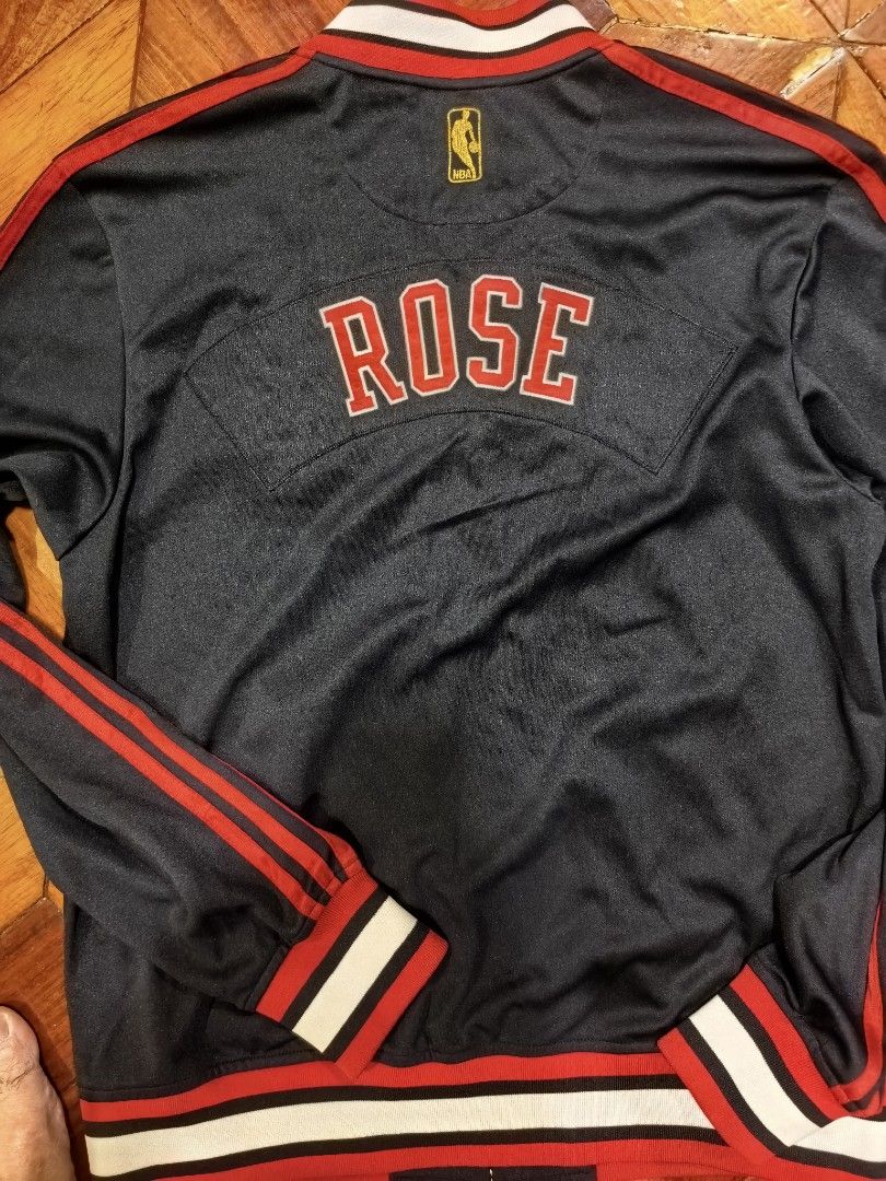 Adidas Derrick Rose Chicago Bulls Jacket (Category: Coats, Jackets and Outerwear) located in Manila. Submitted by snooks1938 (Listing ID 1437791912, Image 1). Description: For Grab!! NBA ADIDAS DERECK ROSE VARSITY JACKET BULLS. Size Medium.. 100% Authentic or money back.. - Adidas Chicago Bulls Derrick Rose jacket - Black base with red and white accents - Features "ROSE" on the back - Adidas and NBA logos - Zip-up style with collar Pm for any Que