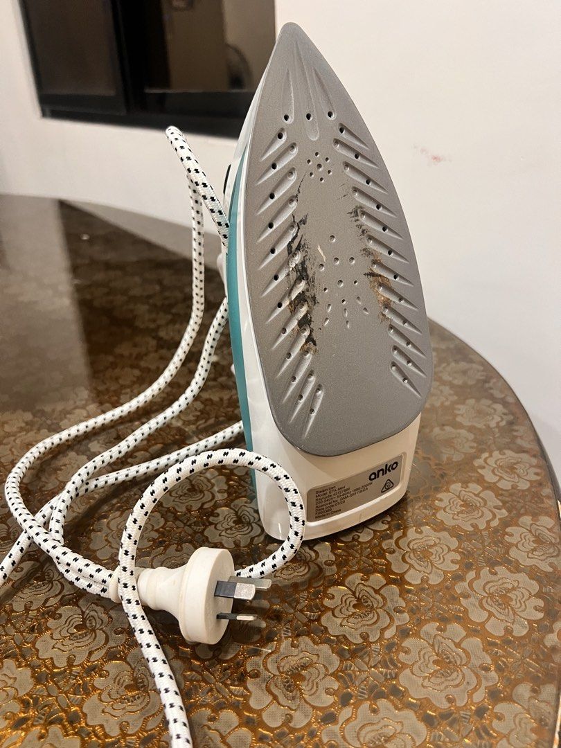Anko Steam Iron (Category: Irons & Steamers) located in Capas. Submitted by skiitt (Listing ID 1437885587, Image 3). Description: Anko steam iron with a white and teal design. Features a water reservoir and various steam settings. The soleplate has multiple steam holes. Includes a power cord with a standard plug. The iron has a handle with a textured grip for comfortable use..