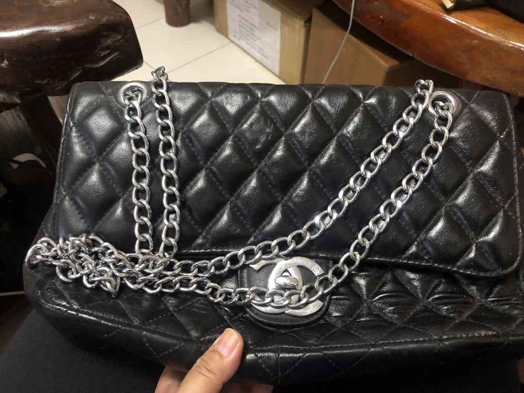 Chanel Quilted Shoulder Bag (Category: Luxury Bags & Wallets) located in Tabuk. Submitted by qurst (Listing ID 1437872135, Image 1). Description: - Black quilted shoulder bag - Silver chain straps - Flap closure with Chanel logo - Magnetic snap closure - Interior pocket and logo lining.
