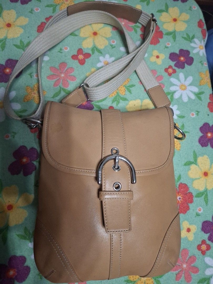 Coach Crossbody Bag (Category: Luxury Bags & Wallets) located in Quezon City. Submitted by lady.fox (Listing ID 1437848344, Image 1). Description: ***Please be reminded that the quality of the picture differs from the actual. Just message me once you need additional pictures or a video clip*** Tan Coach crossbody bag with a silver buckle closure. Features a beige adjustable strap. The interior lining has a Coach logo pattern. There is a small sta