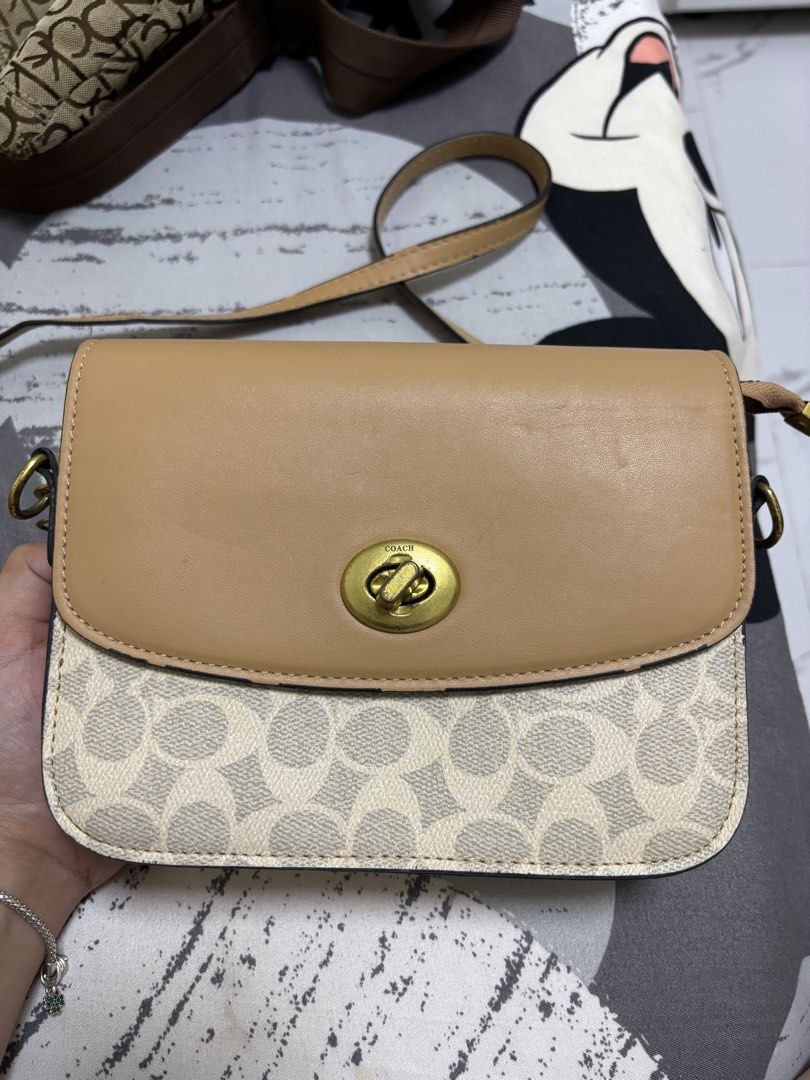 Coach Crossbody Bag (Category: Luxury Bags & Wallets) located in Mangaldan. Submitted by jhustinero42356 (Listing ID 1437920410, Image 2). Description: - Authentic Coach crossbody bag - Features a tan leather flap - Signature Coach pattern on the body - Gold-tone turn-lock closure - Convenient zippered pocket at the back - Interior with multiple compartments for organization - Includes an adjustable strap for comfortable wear.