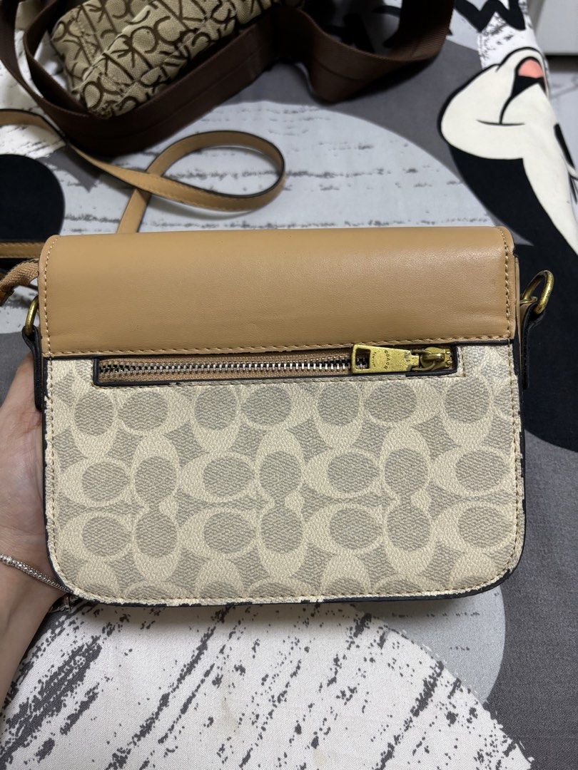 Coach Crossbody Bag (Category: Luxury Bags & Wallets) located in Mangaldan. Submitted by jhustinero42356 (Listing ID 1437920410, Image 3). Description: - Authentic Coach crossbody bag - Features a tan leather flap - Signature Coach pattern on the body - Gold-tone turn-lock closure - Convenient zippered pocket at the back - Interior with multiple compartments for organization - Includes an adjustable strap for comfortable wear.