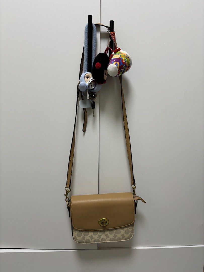 Coach Crossbody Bag (Category: Luxury Bags & Wallets) located in Mangaldan. Submitted by jhustinero42356 (Listing ID 1437920410, Image 1). Description: - Authentic Coach crossbody bag - Features a tan leather flap - Signature Coach pattern on the body - Gold-tone turn-lock closure - Convenient zippered pocket at the back - Interior with multiple compartments for organization - Includes an adjustable strap for comfortable wear.