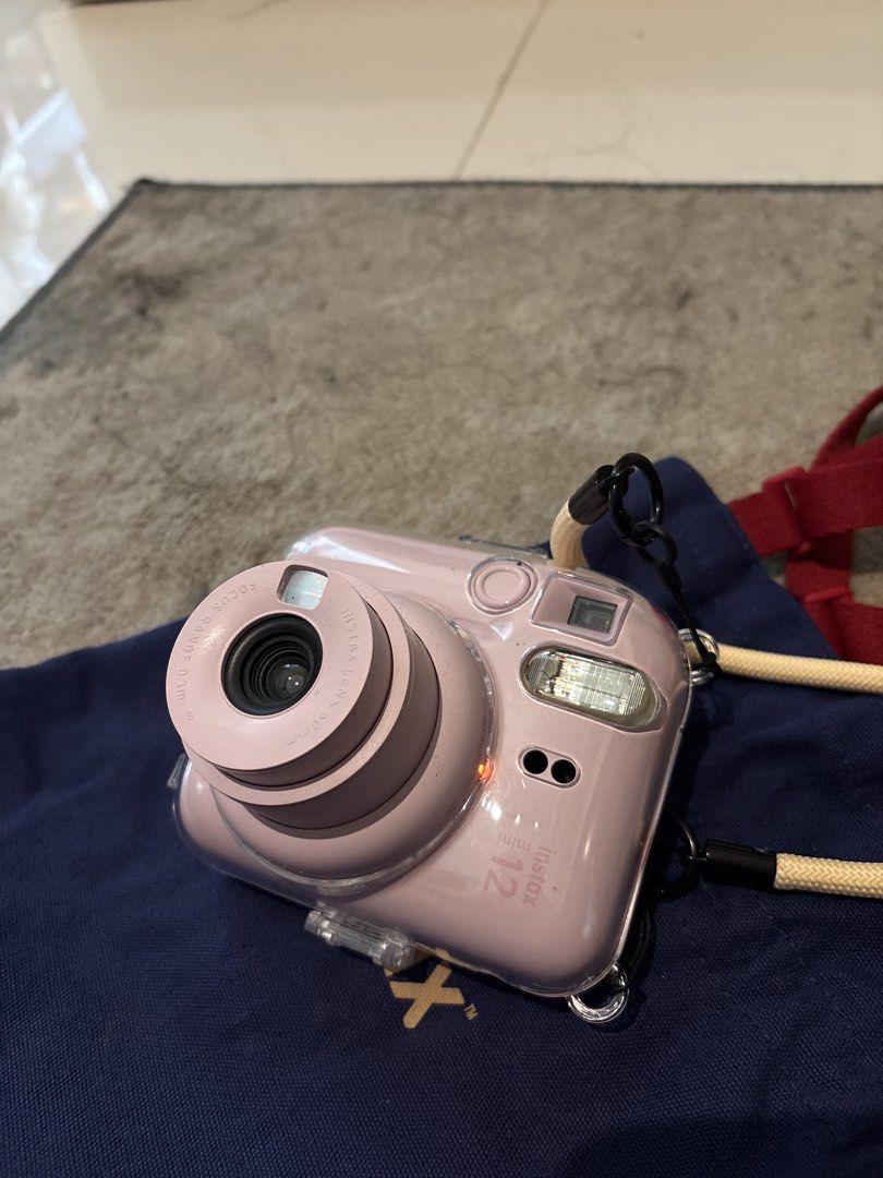 Fujifilm Instax Mini 12 Instant Camera (Category: Cameras) located in Mandaluyong City. Submitted by jienellecatubay (Listing ID 1437775478, Image 3). Description: - Fujifilm Instax Mini 12 instant camera (pink) - Includes clear protective case - Comes with a neck strap - Includes a blue Instax carrying bag - Built-in flash and lens - Perfect for instant photos - complete box .