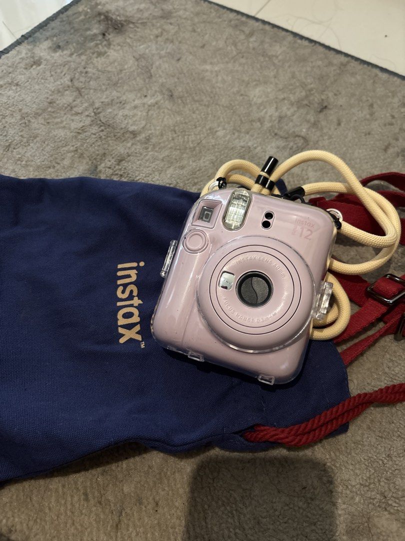 Fujifilm Instax Mini 12 Instant Camera (Category: Cameras) located in Mandaluyong City. Submitted by jienellecatubay (Listing ID 1437775478, Image 1). Description: - Fujifilm Instax Mini 12 instant camera (pink) - Includes clear protective case - Comes with a neck strap - Includes a blue Instax carrying bag - Built-in flash and lens - Perfect for instant photos - complete box .
