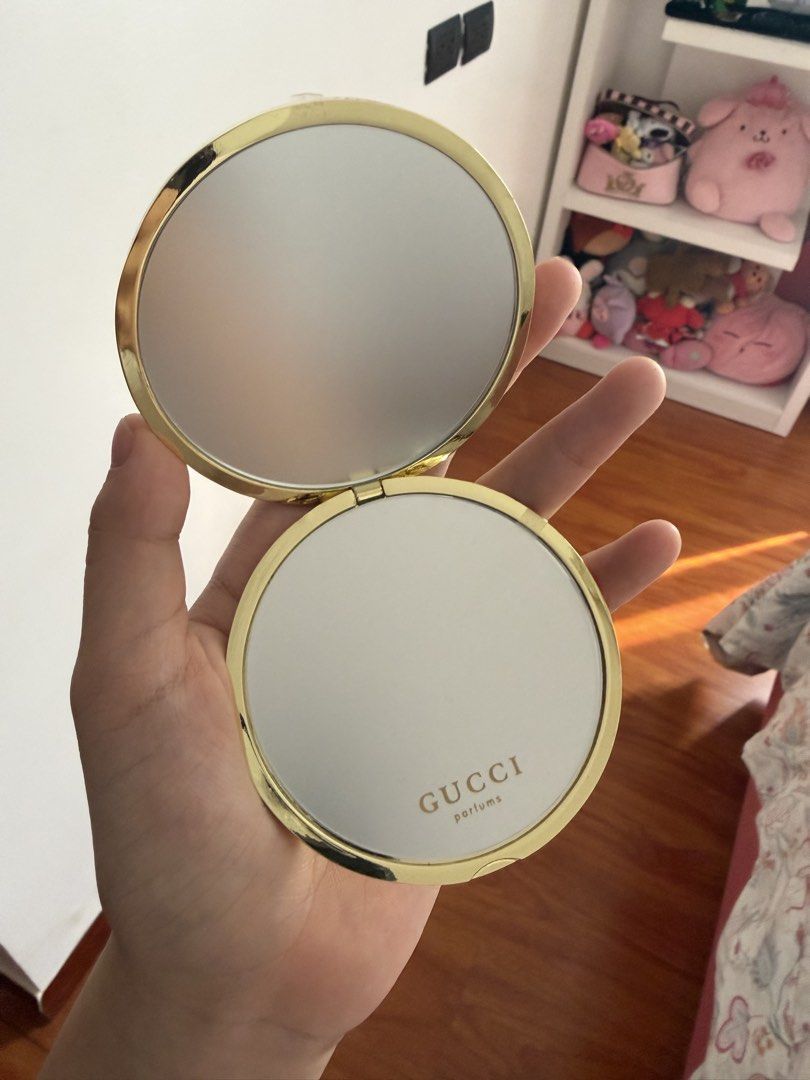 Gucci Perfums Compact Mirror (Category: Mirrors) located in Manila. Submitted by sophia.triz (Listing ID 1437867809, Image 1). Description: - Gucci Perfums compact mirror - Gold-colored casing - Embossed Gucci logo - Comes with a red box - Features two mirrors - One mirror with Gucci Perfums logo.
