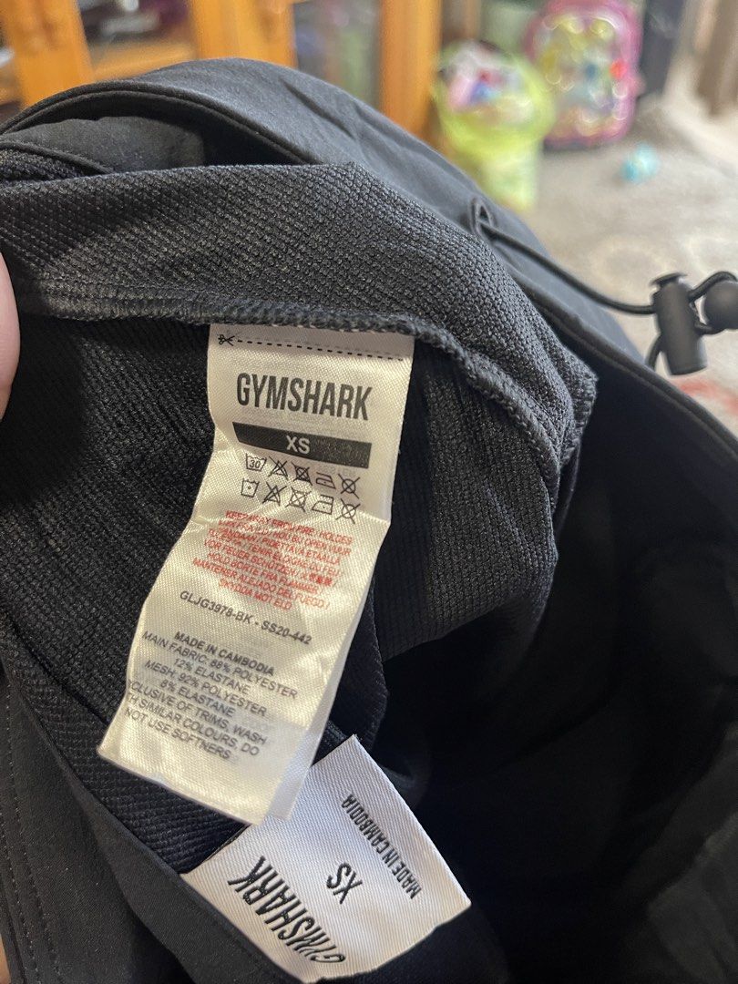 Gymshark Black XS Training Pants (Category: Activewear) located in La Trinidad. Submitted by avessonjam (Listing ID 1437875927, Image 3). Description: - Gymshark training pants - Color: Black - Size: XS - Made in Cambodia - Features: Drawstring and button closure - Design: Sleek, athletic - Suitable for: Workouts and casual wear - Material: Lightweight and durable - Gymshark logo visible.