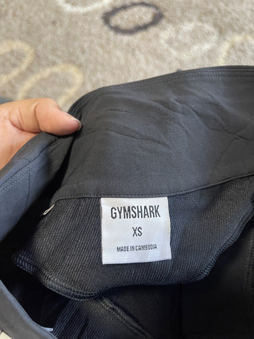 Gymshark Black XS Training Pants (Category: Activewear) located in La Trinidad. Submitted by avessonjam (Listing ID 1437875927, Image 2). Description: - Gymshark training pants - Color: Black - Size: XS - Made in Cambodia - Features: Drawstring and button closure - Design: Sleek, athletic - Suitable for: Workouts and casual wear - Material: Lightweight and durable - Gymshark logo visible.