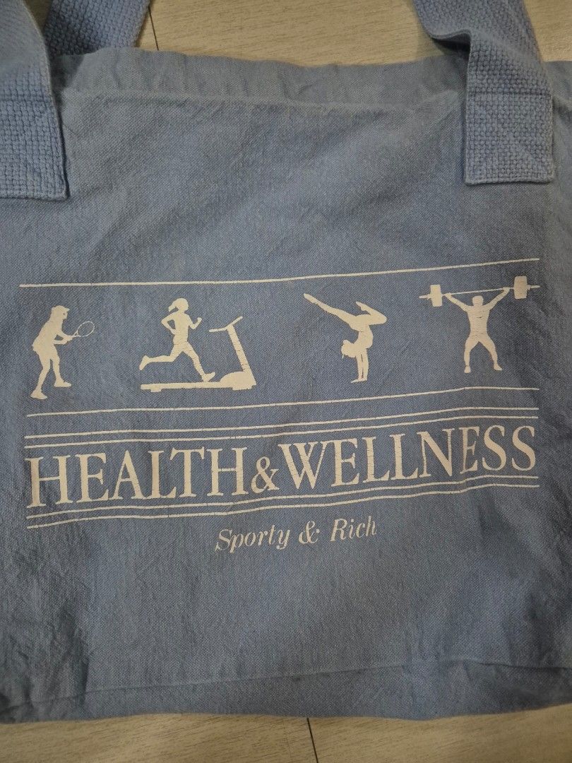 Health & Wellness Tote Bag (Category: Tote Bags) located in Pasig City. Submitted by beeeeeg (Listing ID 1437798073, Image 2). Description: - 'Health & Wellness' design - Light blue fabric - Features fitness figures - Two handles - Includes a small American flag tag - Ideal size for carrying essentials.