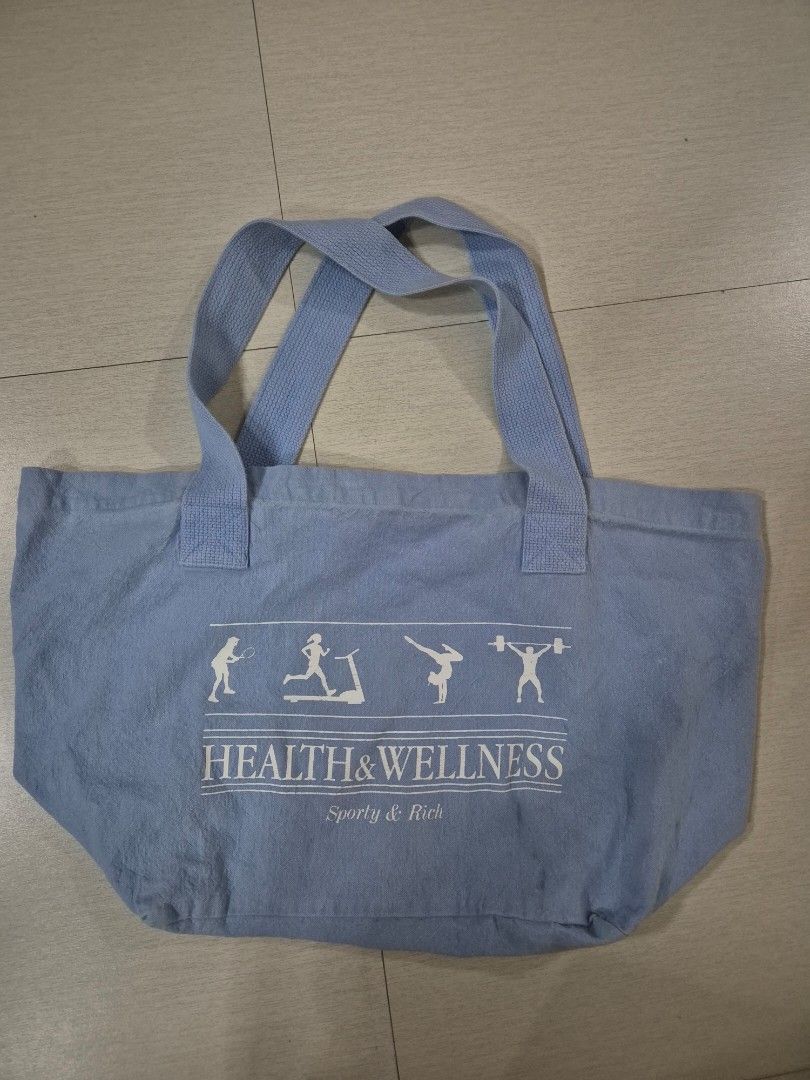Health & Wellness Tote Bag (Category: Tote Bags) located in Pasig City. Submitted by beeeeeg (Listing ID 1437798073, Image 1). Description: - 'Health & Wellness' design - Light blue fabric - Features fitness figures - Two handles - Includes a small American flag tag - Ideal size for carrying essentials.