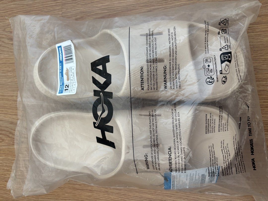 Hoka Recovery Slide 3 - Size 12 (Category: Slippers & Slides) located in Mandaluyong City. Submitted by joebren24 (Listing ID 1437889132, Image 2). Description: - Hoka Recovery Slide 3 sandals - Size: 12 - Color: Light Beige - Condition: New - Comes in original packaging - Features Hoka logo on strap - Packaging includes product information and barcode.