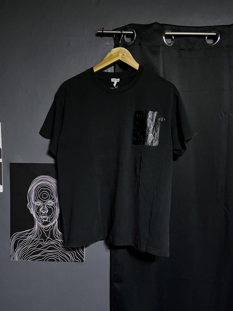 Loewe Black Pocket T-shirt (Category: Tshirts & Polo Shirts ) located in Panabo. Submitted by edition_25 (Listing ID 1437883828, Image 1). Description: Black Loewe T-shirt with a leather pocket. Features the Loewe logo embossed on the pocket. Made in Portugal. Size S. The shirt has a crew neck and short sleeves. The tag is visible, showing the brand and size. - 21 width - 26.5 length - Excellent condition - 9.8/10 color rate.