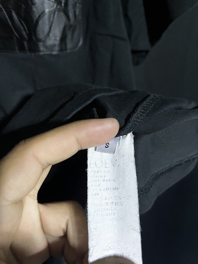 Loewe Black Pocket T-shirt (Category: Tshirts & Polo Shirts ) located in Panabo. Submitted by edition_25 (Listing ID 1437883828, Image 3). Description: Black Loewe T-shirt with a leather pocket. Features the Loewe logo embossed on the pocket. Made in Portugal. Size S. The shirt has a crew neck and short sleeves. The tag is visible, showing the brand and size. - 21 width - 26.5 length - Excellent condition - 9.8/10 color rate.