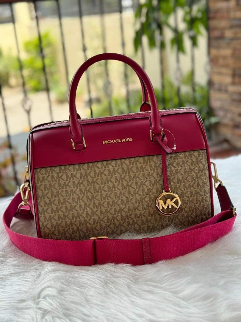 Michael Kors Duffle Bag (Category: Luxury Bags & Wallets) located in Guagua. Submitted by WearDTwinsCollections (Listing ID 1437780825, Image 1). Description: !! ON SALE !!! - On hand, reqdy to ship. - Michael Kors duffle bag - Color: Pink and Brown - Detachable shoulder strap - Gold-tone hardware - MK logo pattern - Top handle - Zip closure.