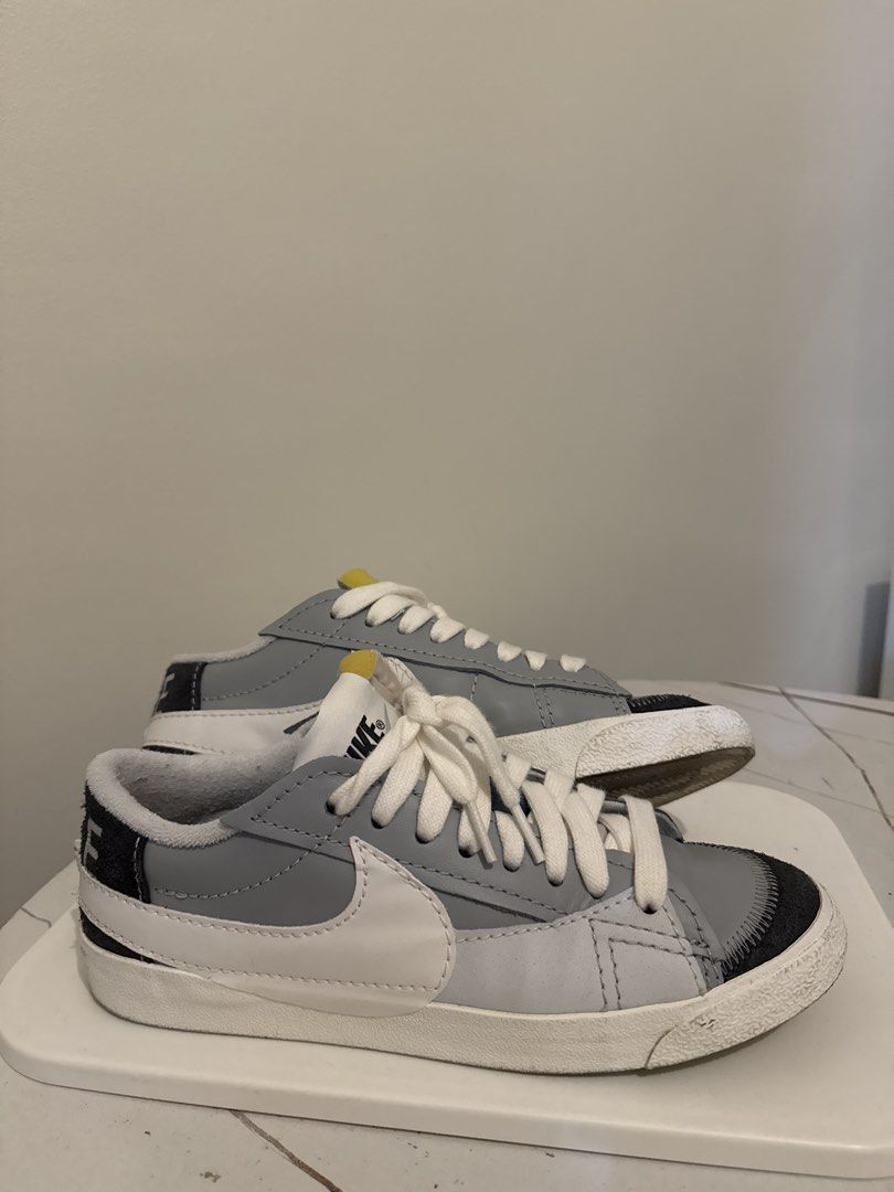 Nike Blazer Low Grey White Sneakers (Category: Sneakers) located in Angeles City. Submitted by ianlester06037 (Listing ID 1437782241, Image 1). Description: Nike Blazer Low sneakers in grey and white. Features a white Nike swoosh on the side and white laces. The toe area has a dark grey accent. The sole is white with some wear. The shoes are displayed on a white surface..