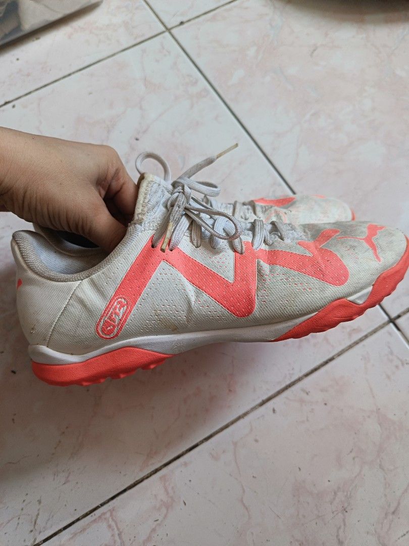 Puma Football Shoes (Category: Sneakers) located in Paombong. Submitted by eveiveneg09 (Listing ID 1437796534, Image 2). Description: - White upper with orange accents - Orange sole - Laced closure - Puma logo on side and heel - Signs of wear on soles.