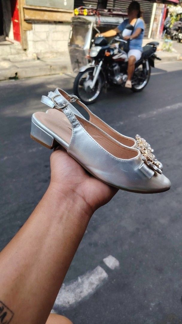 Shein Silver Slingback Sandals with Embellishments (Category: Flats & Sandals) located in Manila. Submitted by fheyyy_02 (Listing ID 1437878394, Image 2). Description: - Silver slingback sandals - Size 33 - Pointed toe design - Decorative embellishment - Small heel - Buckle closure - Pre-owned condition (soles show wear).