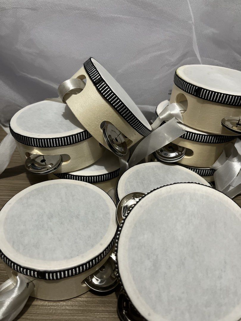 Small Tambourines (Category: Musical Instruments) located in Quezon City. Submitted by raca_preloved (Listing ID 1437845173, Image 2). Description: Used once 9pcs 4in - Small, round tambourines - White drumhead - Light-colored wooden frame with black trim - Silver jingles - White ribbon attached - New and unused - Great for musical activities or party favors.