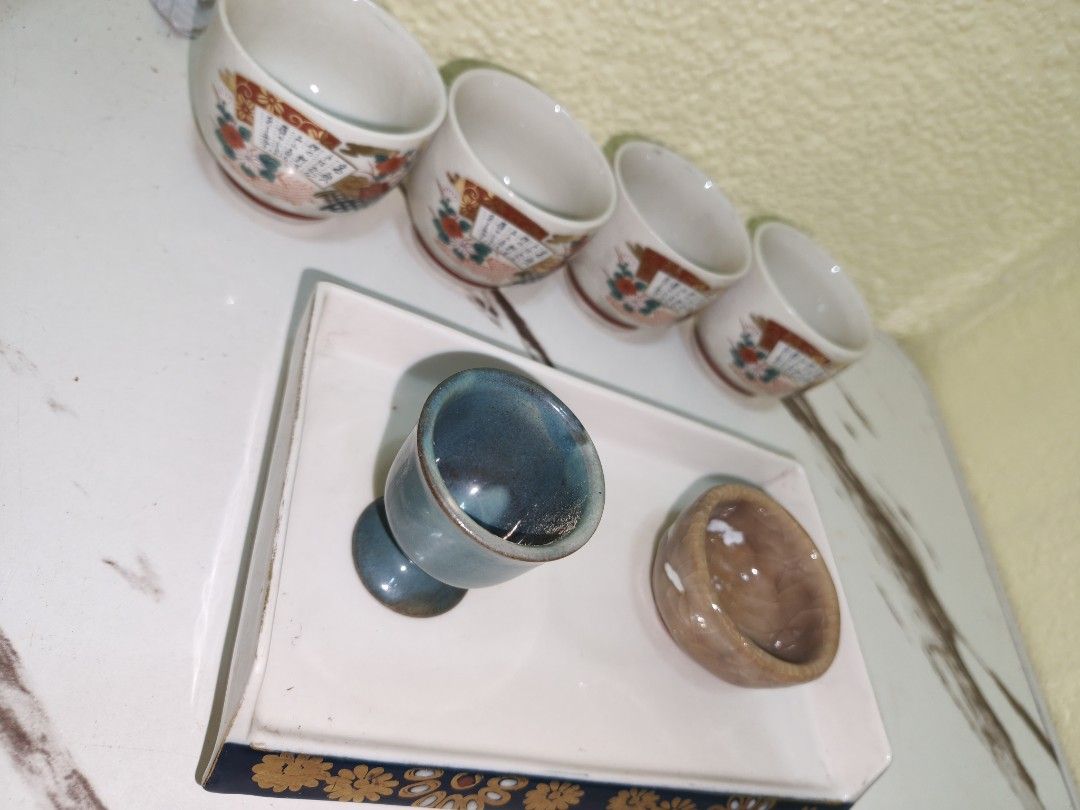 Vintage Japanese Tea Set with Tray (Category: Coffee & Tea Tableware) located in Manila. Submitted by reascheyss51406 (Listing ID 1437799072, Image 3). Description: - Vintage Japanese tea set - Includes: - Four small cups with floral and fan designs - One blue cup - One small brown bowl - Features a white tray with a decorative blue border and gold floral accents - Perfect for serving tea or as a decorative piece.