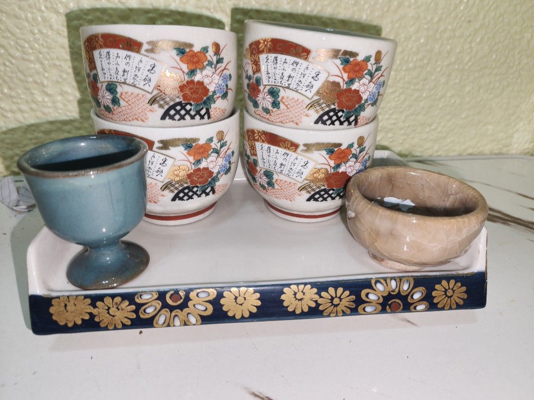 Vintage Japanese Tea Set with Tray (Category: Coffee & Tea Tableware) located in Manila. Submitted by reascheyss51406 (Listing ID 1437799072, Image 1). Description: - Vintage Japanese tea set - Includes: - Four small cups with floral and fan designs - One blue cup - One small brown bowl - Features a white tray with a decorative blue border and gold floral accents - Perfect for serving tea or as a decorative piece.