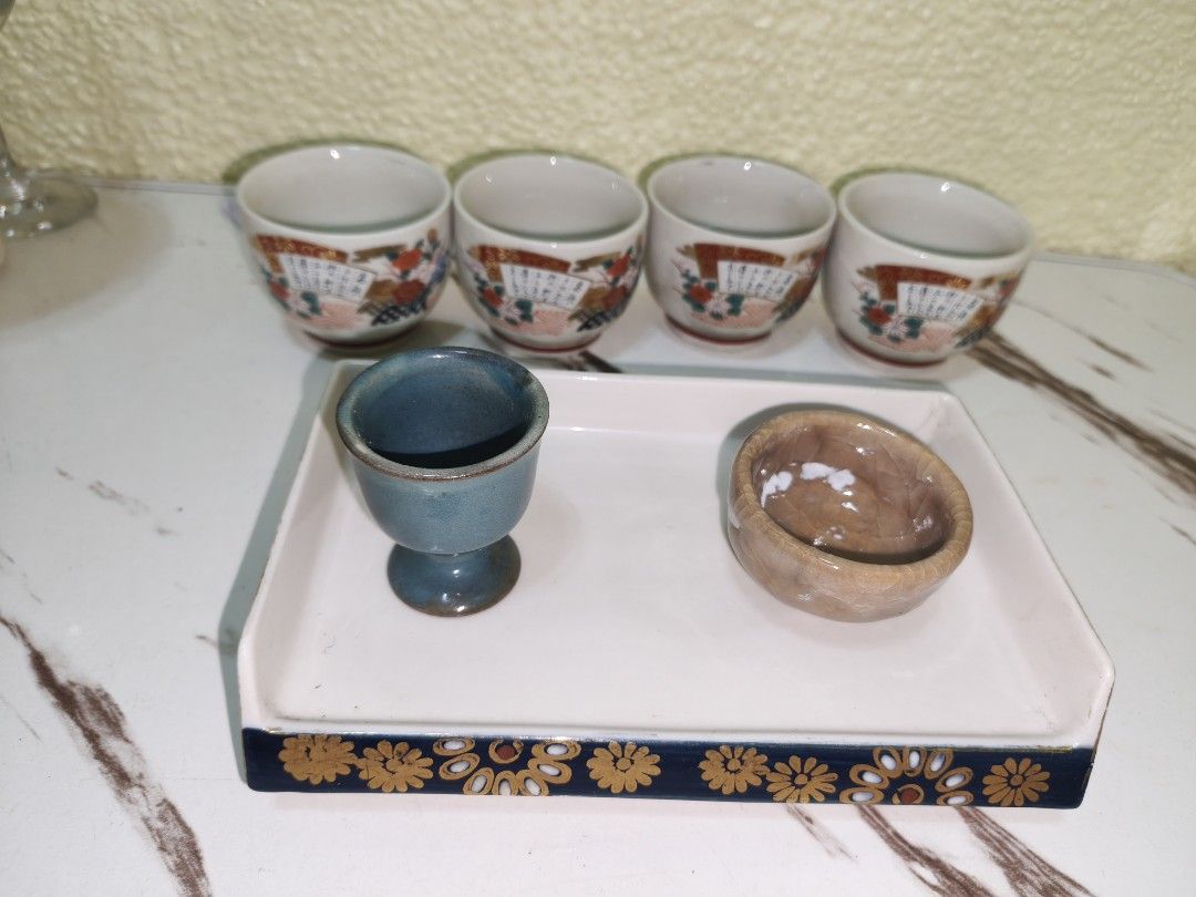 Vintage Japanese Tea Set with Tray (Category: Coffee & Tea Tableware) located in Manila. Submitted by reascheyss51406 (Listing ID 1437799072, Image 2). Description: - Vintage Japanese tea set - Includes: - Four small cups with floral and fan designs - One blue cup - One small brown bowl - Features a white tray with a decorative blue border and gold floral accents - Perfect for serving tea or as a decorative piece.
