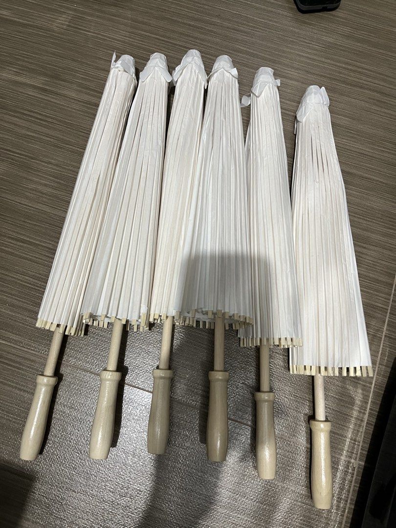 White Paper Umbrellas Parasol (Category: Umbrellas) located in Quezon City. Submitted by raca_preloved (Listing ID 1437844448, Image 1). Description: Used once in wedding shoot. 1 unused 60cm - Set of 6 white paper umbrellas - Features classic pleated paper canopy - Wooden handles - Ideal for events, photoshoots, and decorations.